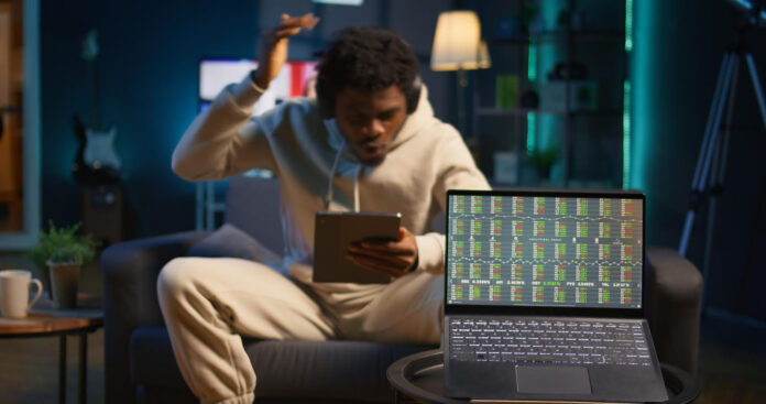 Un homme utilisant sa tablette, assis sur un canapé